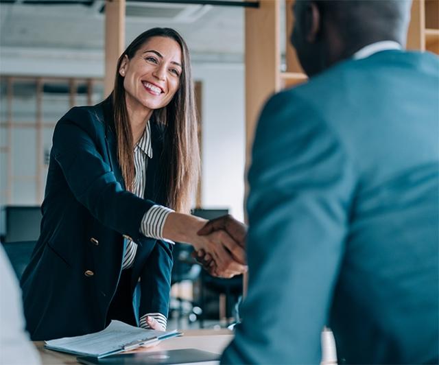 An agent smiles as she greets her new client - WFG is not an MLM