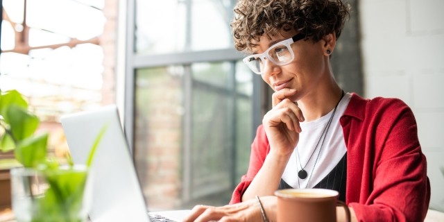 Woman in red looking at laptop screen