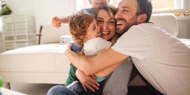 Parents and toddlers sharing a group hug