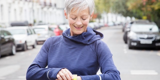 Woman checks her watch while walking across the street