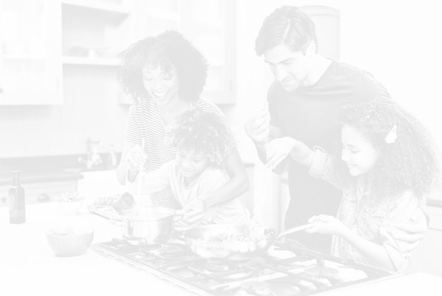 Happy family cooking over a stove together
